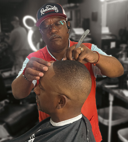 "a picture of a Roosevelt Williams cutting a bald fade"